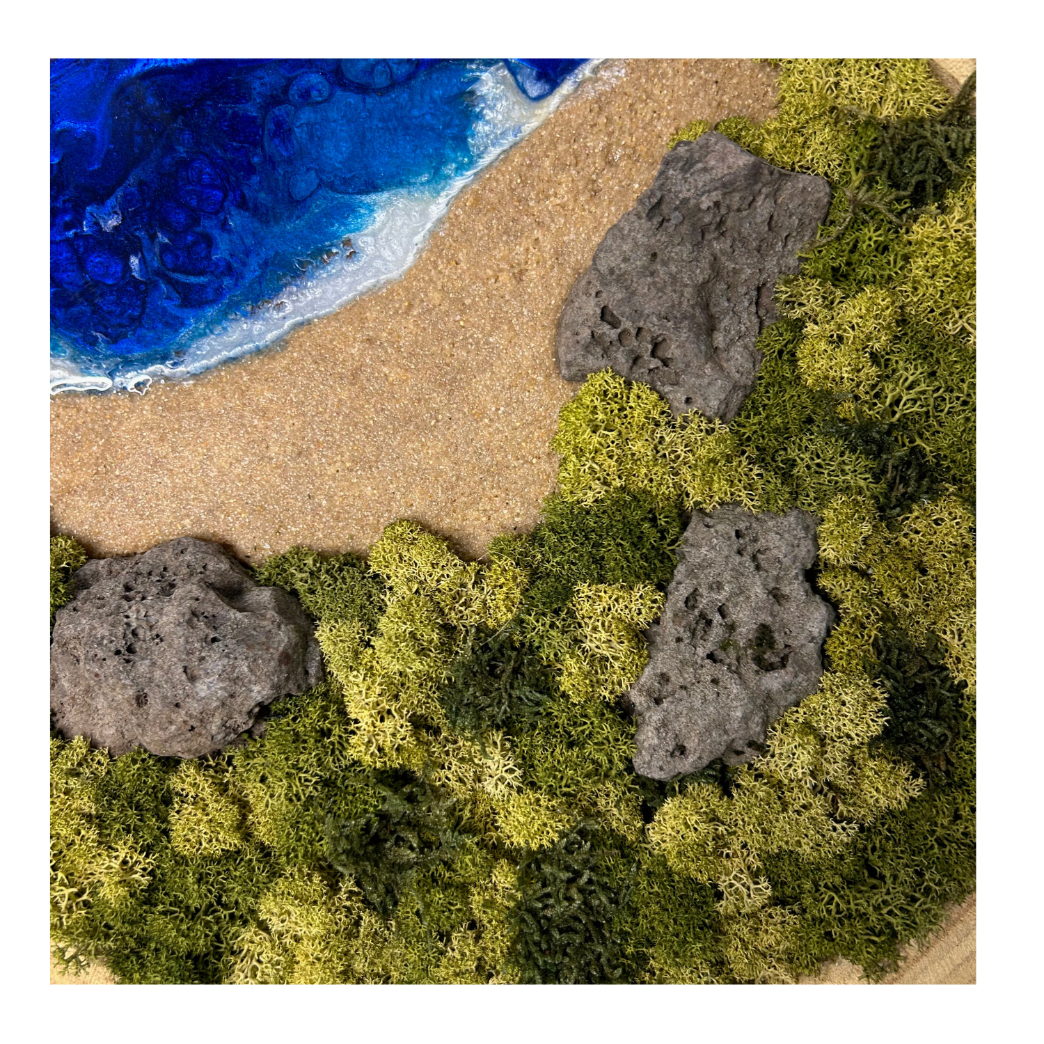 Detailaufnahme Moos- und Meerbild in einer natürlichen, echten Baumscheibe. Mit einem Strand, blauem Meer aus Resin, einem "Wald" aus konserviertem Moos und echten Steinen (Lava).