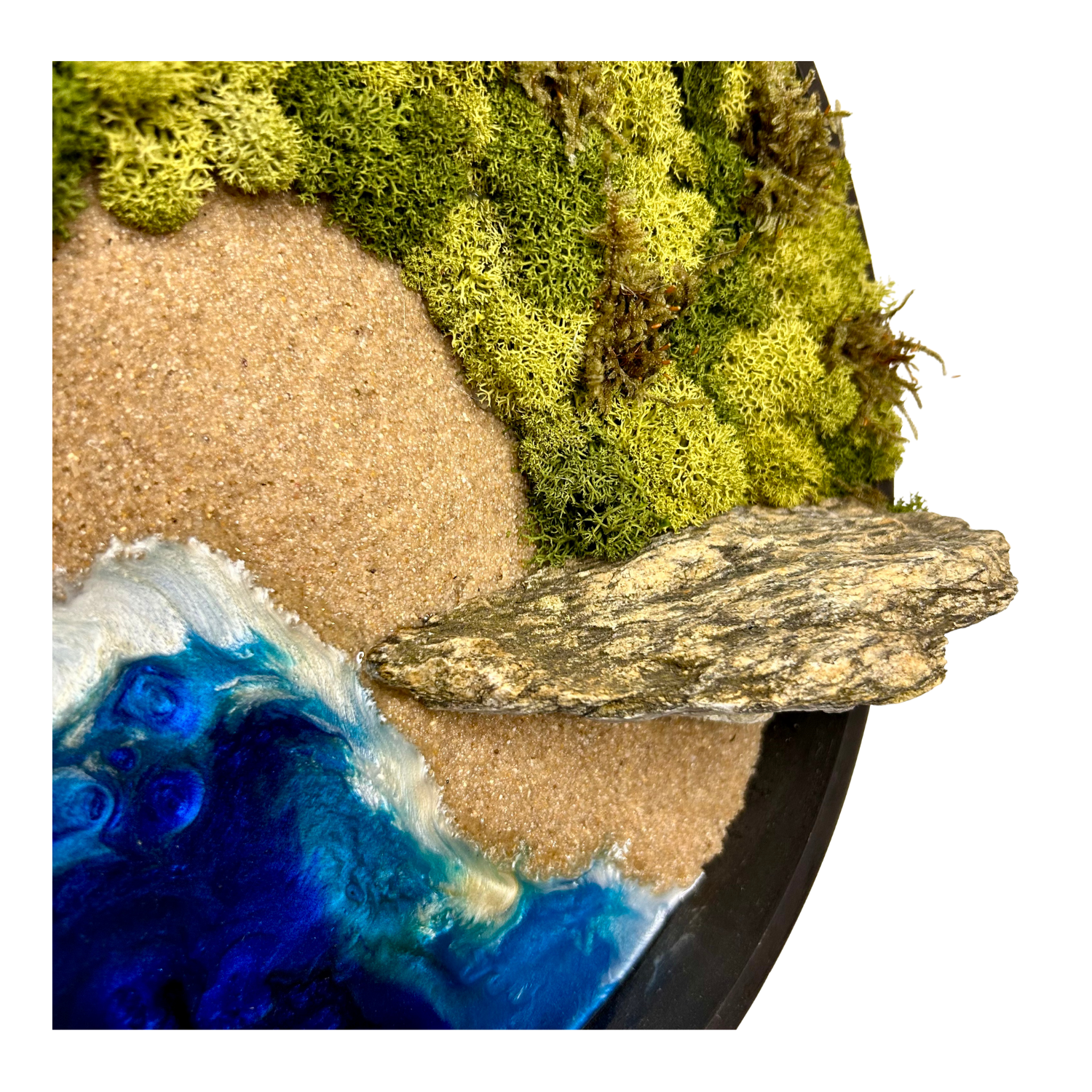 Nahaufnahme meines Moos- und Meerbildes mit Epoxidharz-Meer, Strand aus echtem Sand, Pflanzen und Wäldern aus konserviertem, echten Moos, sowie herausragenden spitzen Felsen aus Naturstein.