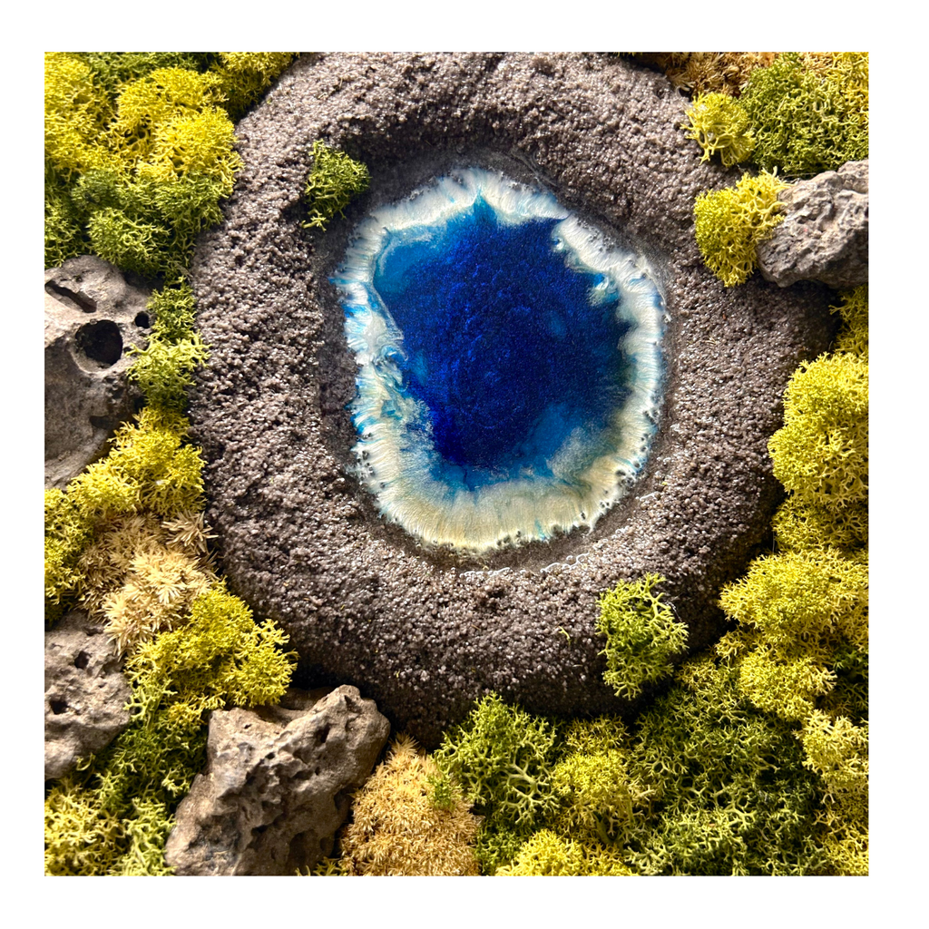 Detailaufnahme des KaterSees. Moosbild in einer natürlichen, echten Baumscheibe. Mit einem modellierten KraterSee mit Wasser aus Resin, einem "Wald" aus konserviertem Moos und echten Steinen (Lava). 