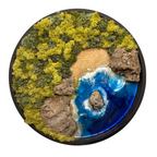 Rundes Moos- und Meerbild mit einer rauen Küste aus Natursteinen und einem wilden Meer aus Epoxidharz, das sich an den Wellen bricht.  Das Bild enthält Moos, Sand und echten Stein.  