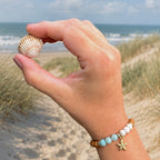 Edelsteinarmband "Dünenzauber" mit weißem Jaspis, versteinertem fossilen Holz, Amazonit und einem vergoldeten Seestern-Anhänger sowie vergoldeten Elementen. Ein Hauch Nordsee für dein Handgelenk. (Tragefoto) 