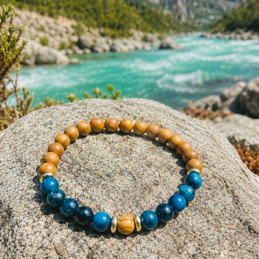 Edelsteinarmband "Fluss der Zeit" mit blauem Tigerauge und versteinertem, fossilen Holz sowie vergoldeten Elementen. 