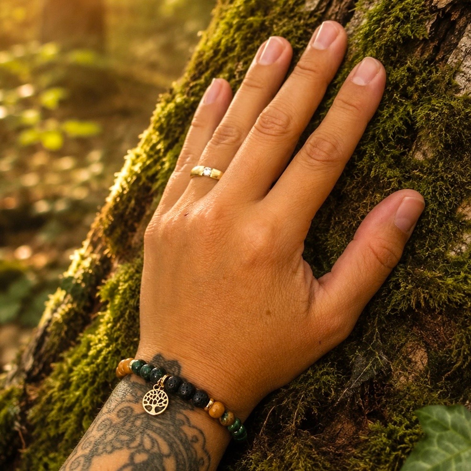 Armband mit versteinertem Holz, Moosachat, Lava und einem vergoldetem Lebensbaum-Anhänger. Das Armband erinnert an einen Wald, voller Magie und wirkt erdend. 