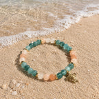 Edelsteinarmband "Spuren im Sand" mit Aquamarin, Pfirsichquarz (Peach Quartz) und einem vergoldeten Schildkröten-Anhänger sowie vergoldeten Elementen. Ein Hauch Meer für dein Handgelenk.