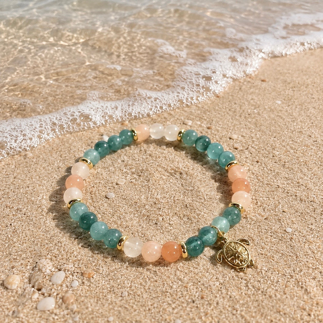 Edelsteinarmband "Spuren im Sand" mit Aquamarin, Pfirsichquarz (Peach Quartz) und einem vergoldeten Schildkröten-Anhänger sowie vergoldeten Elementen. Ein Hauch Meer für dein Handgelenk.