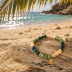 Edelsteinarmband "Unter Palmen" mit Moosachat, Calcit und Seraphinit, einem vergoldeten Monstera-Anhänger sowie vergoldeten Elementen. Ein Hauch Palmenstrand für dein Handgelenk. 