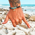Edelstein Armband "Hang Loose" mit Lava, Chalcedon und einer vergoldeten Walflosse als Anhänger. Dieses Armband symbolisiert wilde Wellen, sonnenwarme Haut und schreit nach "Mach dich locker und reite deine eigene Welle". Sei wild und frei - du musst heute nicht wissen, was morgen kommt. 