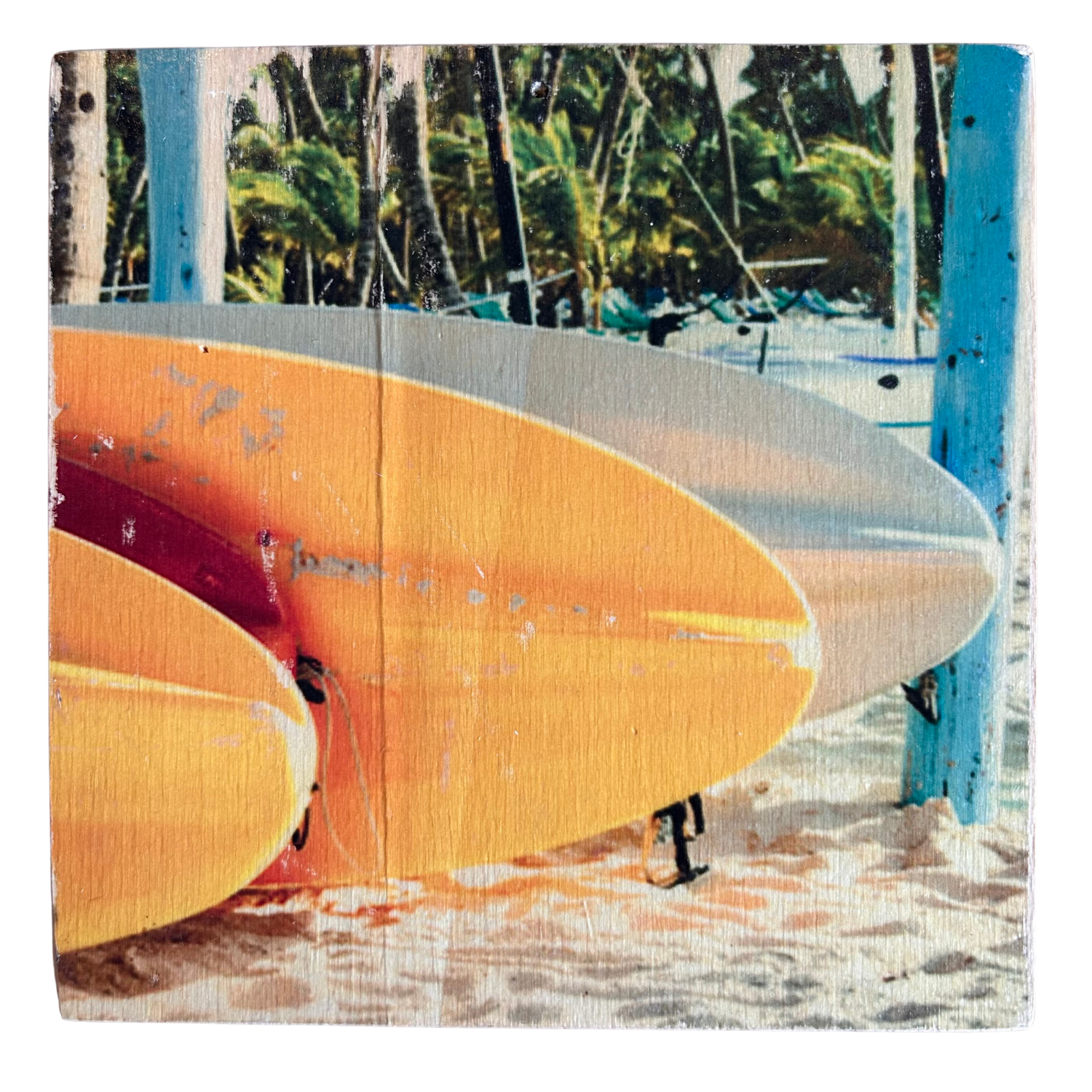 Gelb-orange-farbene Surfbretter liegen auf dem Sand, im Hintergrund sind Palmen. Format 15x15cm. Handgefertigter Fotodruck auf Holz 