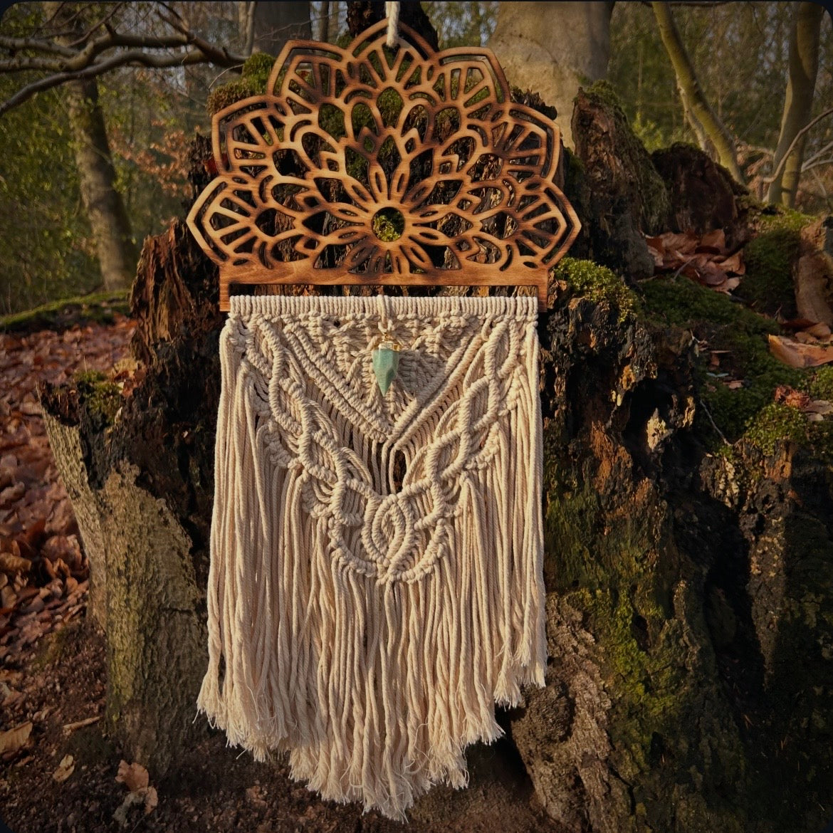 Sandfarbenes Makramee aus reiner Baumwolle an ein Mandala aus geflämmten Holz geknüpft. Verziert mit einem Pendel-Edelstein aus Amazonit. 