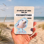Postkarte mit Möwe und einem lustigen Spruch: "Ich möchte mit Ihnen über Ihr Fischbrötchen reden". 