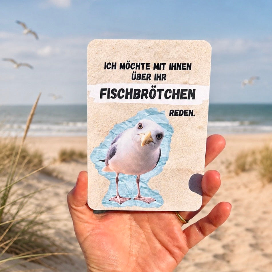Postkarte mit Möwe und einem lustigen Spruch: "Ich möchte mit Ihnen über Ihr Fischbrötchen reden". 