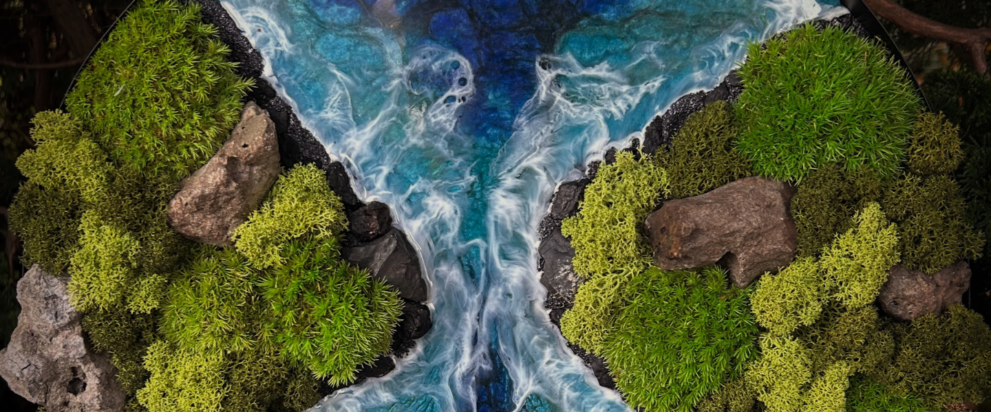 Der Banner zeigt einen Ausschnitt von einem meiner Moosbilder. Schwarzer Strand mit echten Lavasteinen. Wellen aus Epoxyd, die sich in einem wilden Fluss an zwei Meerengen brechen. Rechts und links zwei Inseln mit verschiedenen Moosarten begrünt. 