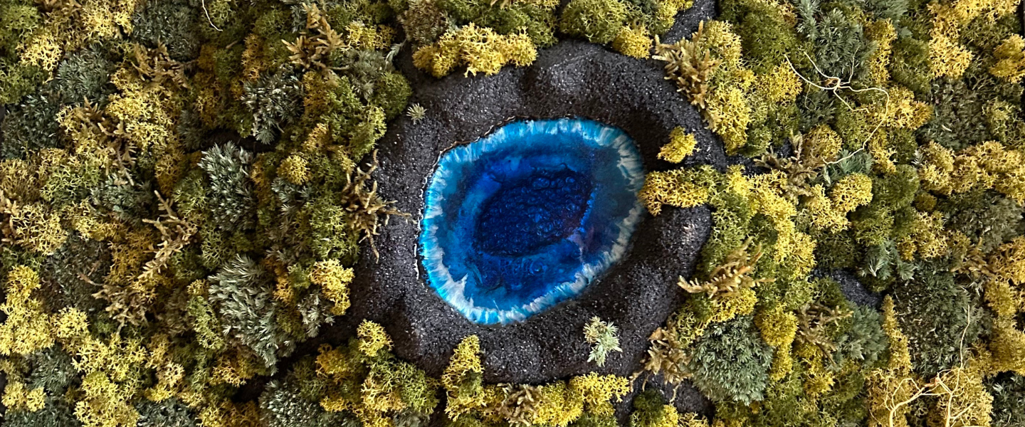 Bildauschschnitt von meinem Moosbild mit einem Vulkansee in der Mitte. Der Vulkan wurde von Hand aus Modelliermasse gefertigt und mit schwarzem Sand überzogen. 
