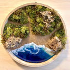 Moosbild "Meerpfade" . Hier sieht man ein Meer mit Wellen aus Resin, einen Strand mit hellem Sand, kleine Pfade zwischen den Moosbereichen, Natursteine und grünes, konserviertes Moos. Naturkunst von Moos und Meer in Oberhausen.