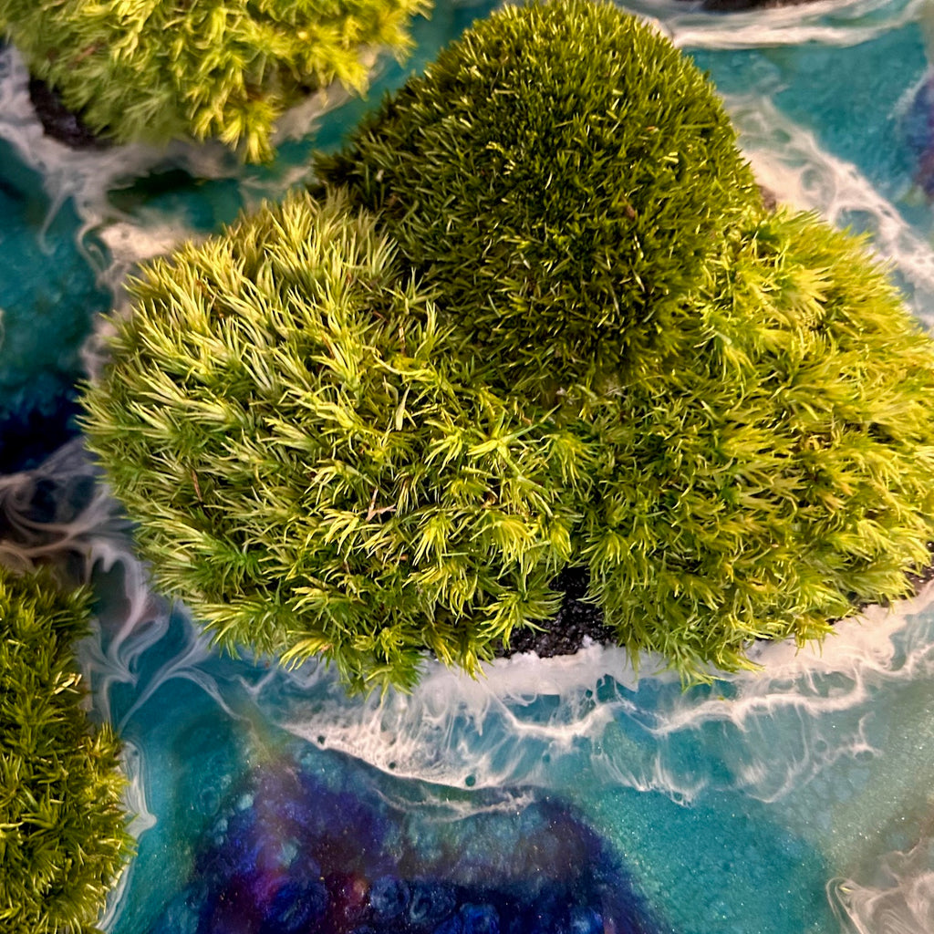 Detailaufnahme 2 des Moosbildes "Waterworld". Hier sieht man ein Meer mit Wellen aus Resin gegossen, Inseln mit schwarzem Sand und grünem, konserviertem Moos. Naturkunst von Moos und Meer in Oberhausen.